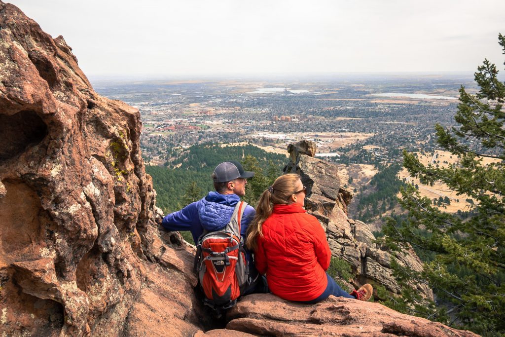 Tim and Sarah sit on a cliff overlooking Boulder, Colorado