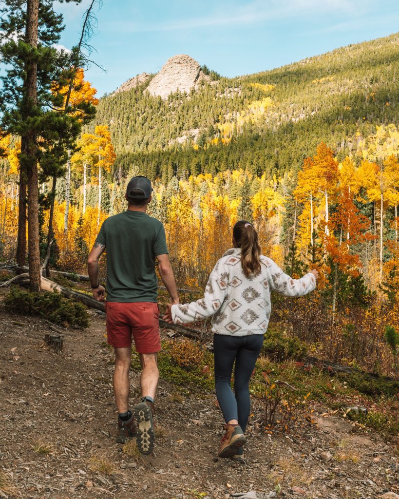 Tim and Sarah frolic among golden aspens in golden gate canyon state park in the fall